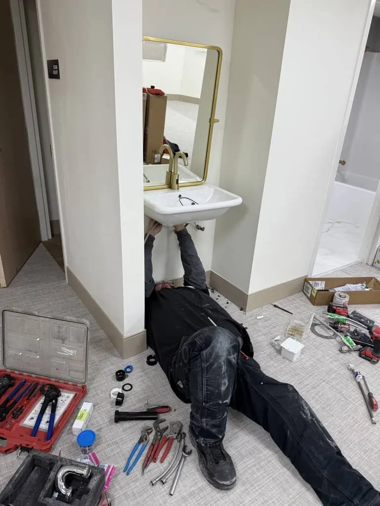 Plumber working under a kitchen sink in Salt Lake City